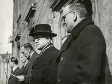 Předseda Národního výboru hlavního města Olomouce Václav Stibor-Kladenský oznamuje 21. února 1946 z balkonu radnice shromážděným Olomoučanům, že Prozatímní Národní shromáždění uzákonilo obnovení olomoucké univerzity pod názvem Univerzita Palackého v Olomouci. Zprava doleva: náměstek předsedy NV hl. města Olomouce Josef Frydrych (ČSL), děkan Cyrilometodějské fakulty bohoslovecké v Olomouci prof. ThDr. František Cinek, předseda NV hl. města Olomouce Václav Stibor-Kladenský (KSČ), předseda Okresního národního výboru Olomouc-venkov Otto Ryznar-Kant, neidentifikovaný funkcionář. Archiv UP v Olomouci.